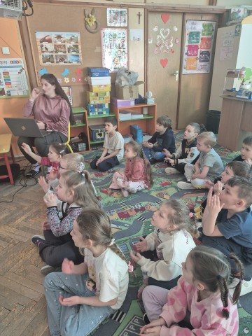 Dzieci uczą się piosenki w języku migowym